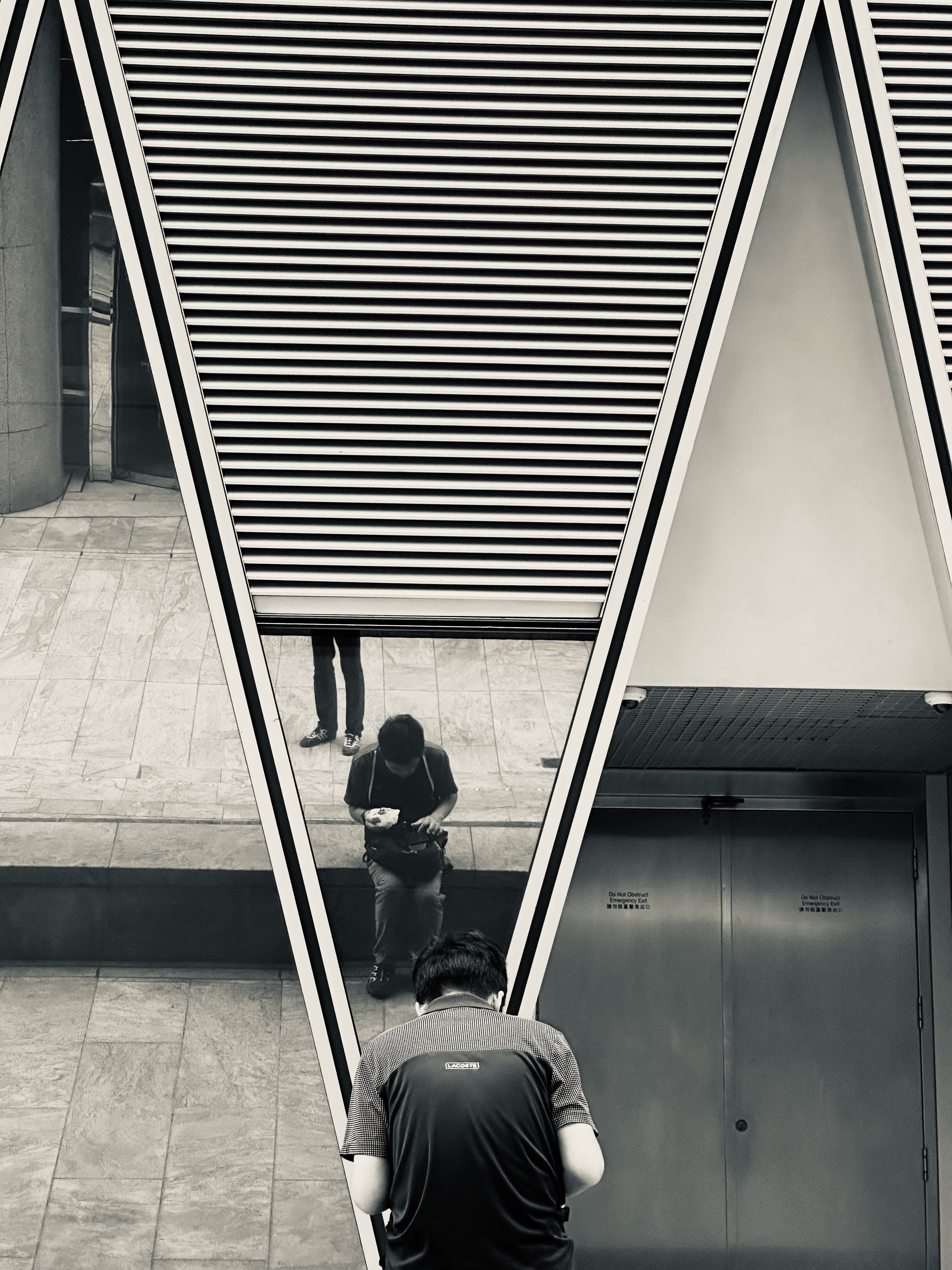 Angular architectural frames crossing around small figures on different levels.